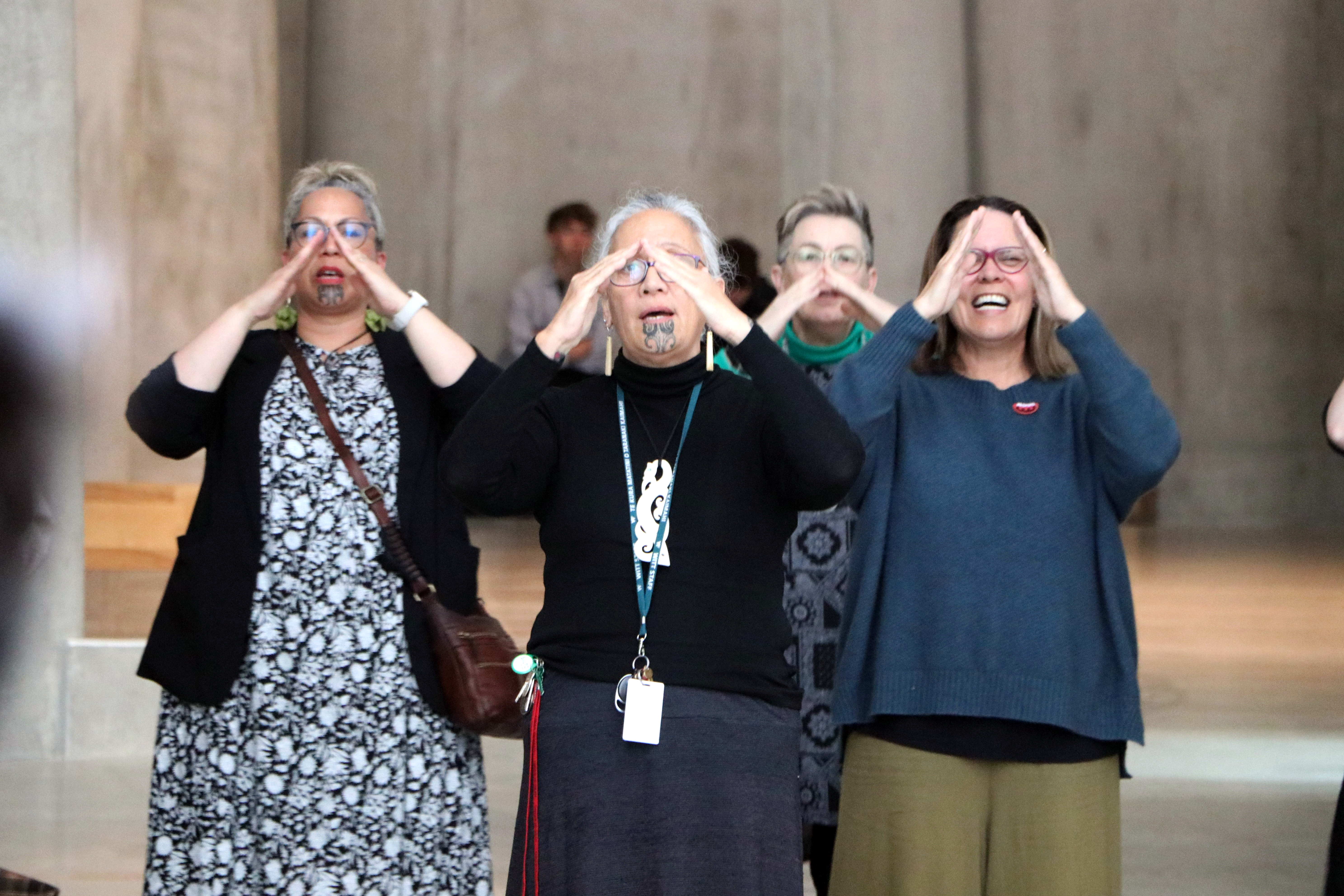 A group of people gathered in the Gallery space, singing waiata