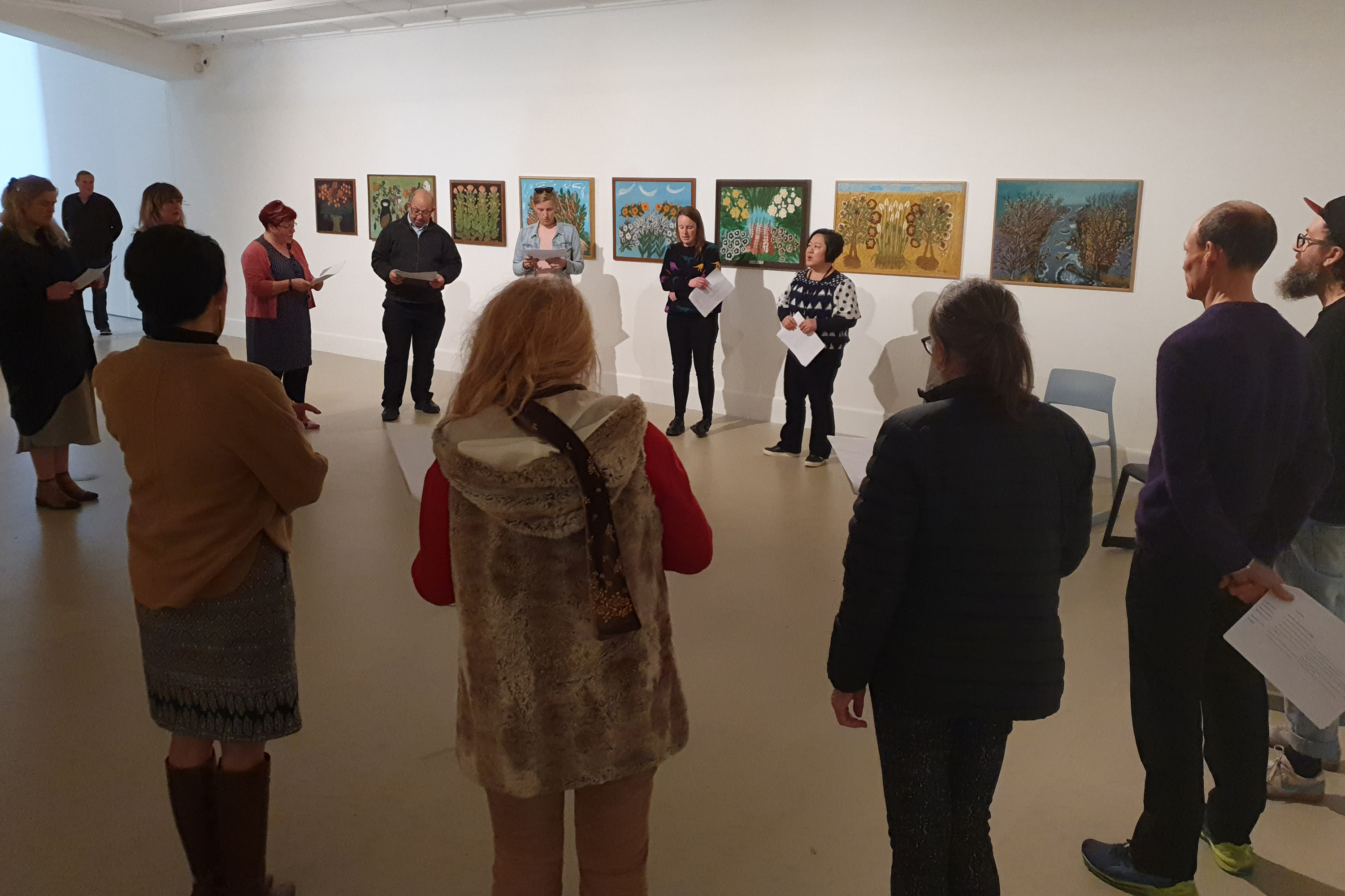 A group of people gathered in the Gallery space, singing waiata